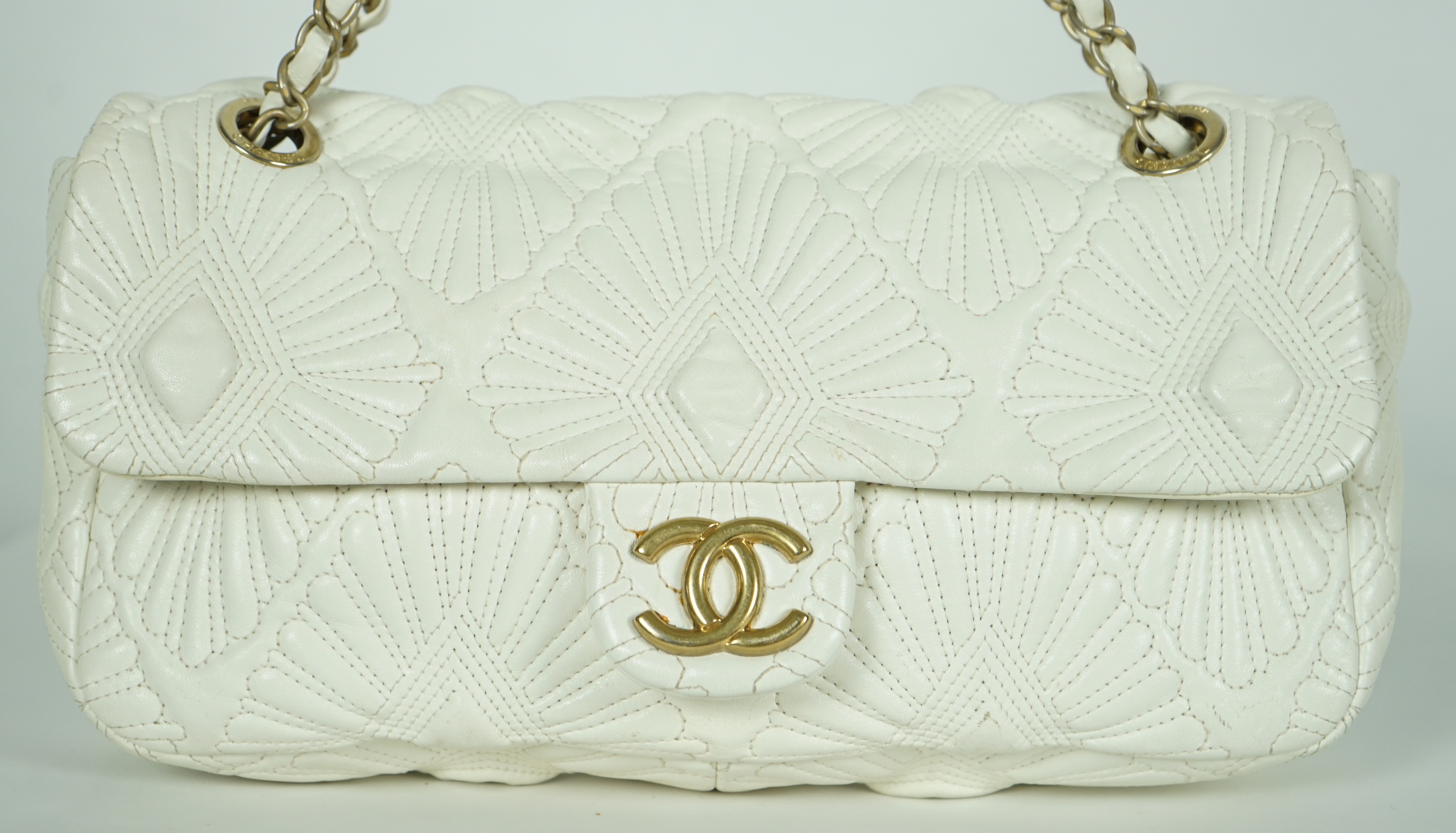 A white quilted Chanel shoulder bag, with maker’s dust bag, height 17cm, overall height 37cm, width 30cm, depth 7cm, Please note this lot attracts an additional import tax of 20% on the hammer price